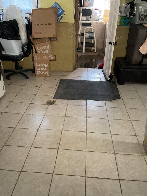 # Plumbing Service Report

Responded to water intrusion emergency in residential property where standing water had accumulated on concrete garage floor and was threatening to enter main living areas. Assessed the situation and documented existing water damage, noting water pooling near the threshold between garage and interior tiled spaces. Provided professional consultation on necessary repairs to address the water infiltration issue, presented repair options to resolve the underlying plumbing concern, and successfully closed the sale for comprehensive remediation services to prevent future flooding and protect the home's interior from water damage.