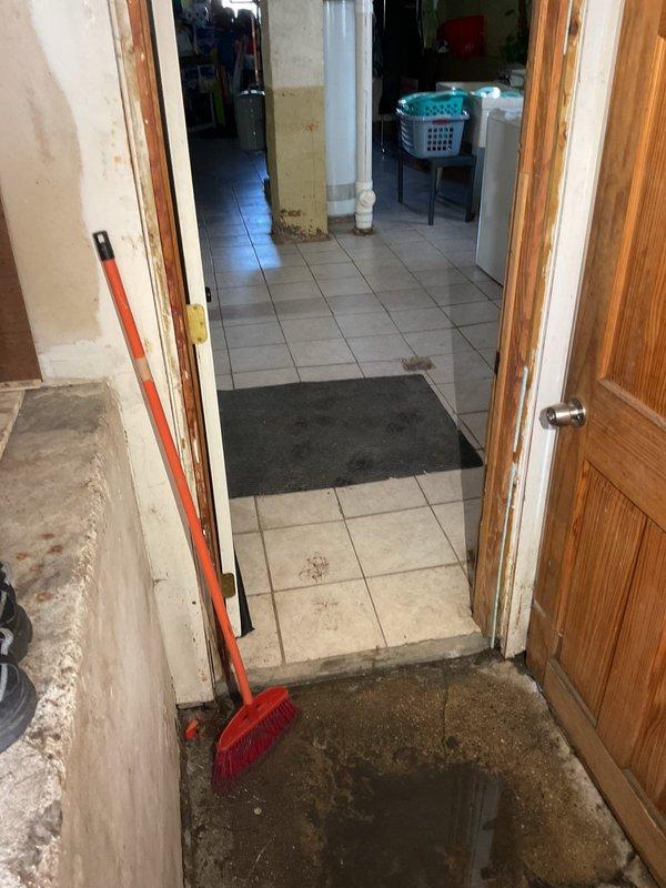 # Plumbing Service Report

Responded to water intrusion emergency in residential property where standing water had accumulated on concrete garage floor and was threatening to enter main living areas. Assessed the situation and documented existing water damage, noting water pooling near the threshold between garage and interior tiled spaces. Provided professional consultation on necessary repairs to address the water infiltration issue, presented repair options to resolve the underlying plumbing concern, and successfully closed the sale for comprehensive remediation services to prevent future flooding and protect the home's interior from water damage.