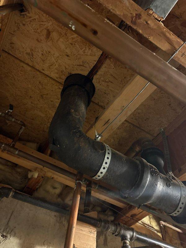 Responded to emergency call for active water leak in basement near furnace area. Upon arrival, conducted thorough inspection of plumbing systems, drainage lines, and surrounding mechanical components in the vicinity of the hot water heater where customer reported large dripping. 

Investigated copper supply lines, drainage piping, and ductwork throughout the basement ceiling space to locate the source of the leak. Examined exposed joists, OSB sheathing, and all visible plumbing connections for signs of water damage, moisture accumulation, or active dripping. Traced potential leak paths from upper floor drainage systems down through the basement infrastructure.

During inspection, identified significant fire damage to an electrical outlet fixture on wooden door frame, which required documentation but was outside the scope of the plumbing leak investigation. Photographed all relevant areas including mechanical systems, ductwork, and structural components for documentation purposes. Compl