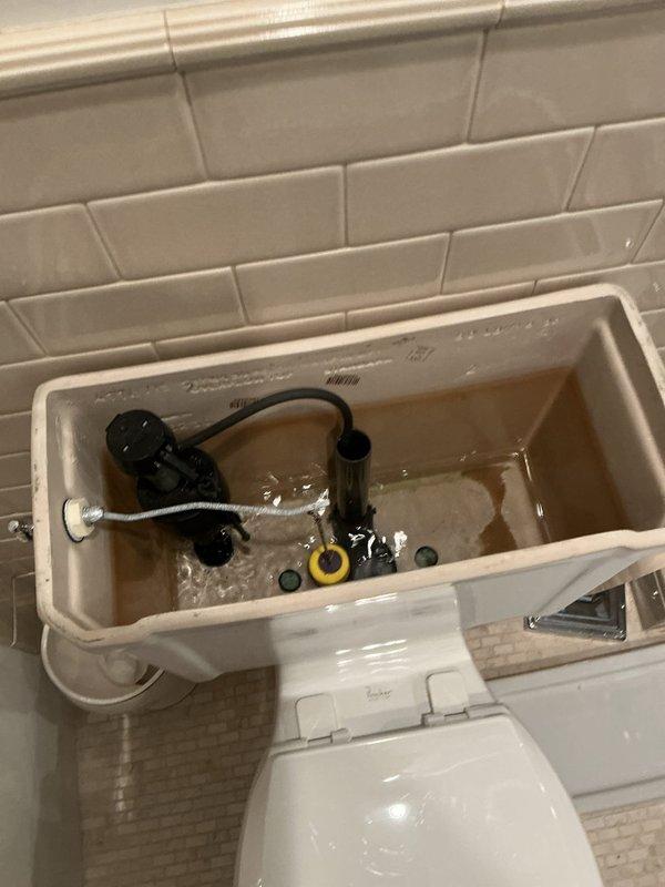 Responded to customer report of toilet running continuously for two weeks in a 17-year-old residential property. Upon arrival, removed tank lid and inspected internal flushing mechanism. Found discolored water in tank with low fill level, indicating potential fill valve malfunction. Examined float assembly, overflow tube, flush valve, and flapper components for wear and proper operation. Identified issues with the fill valve assembly causing continuous water flow. Adjusted float mechanism and tested flush cycle to ensure proper tank refill and shutoff. Verified all internal components were functioning correctly and water flow ceased after repairs. Tank refilled to appropriate level with clear shutoff operation confirmed.