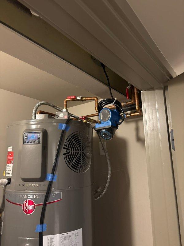 Responded to callback for multiple system issues including sump pump battery alarm, non-functioning ejector pump, and tankless water heater performance concerns. Inspected previously installed sump pump battery backup system showing red indicator light and audible alarm, ejector pump installation requiring operational assessment, and existing tankless water heater system with reported performance issues. Documented current conditions of plumbing installations including copper piping configurations, recirculation components, and electrical connections throughout utility area.