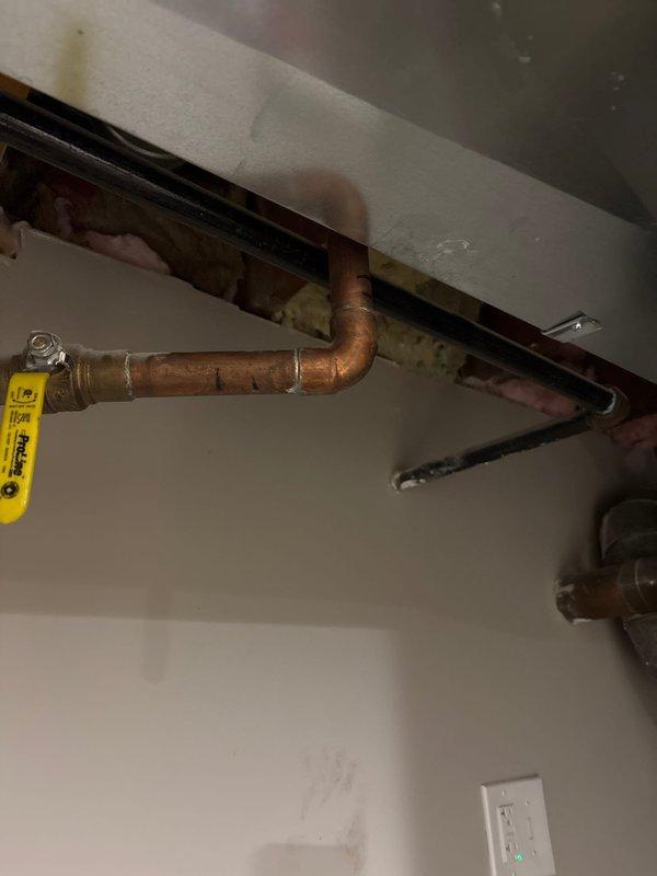 Responded to callback for multiple system issues including sump pump battery alarm, non-functioning ejector pump, and tankless water heater performance concerns. Inspected previously installed sump pump battery backup system showing red indicator light and audible alarm, ejector pump installation requiring operational assessment, and existing tankless water heater system with reported performance issues. Documented current conditions of plumbing installations including copper piping configurations, recirculation components, and electrical connections throughout utility area.