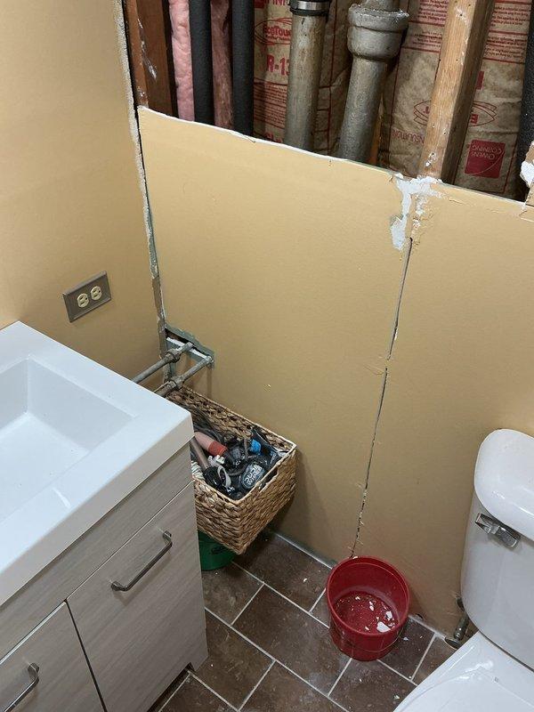 Responded to service call for bathroom plumbing assessment. Upon arrival, accessed concealed drain and waste lines by removing section of bathroom wall behind vanity area. Exposed vertical plumbing stack and associated drainage piping within wall cavity to evaluate system condition and identify source of drainage concerns. Documented existing plumbing configuration including PVC waste lines and supply connections for estimate preparation and future repair planning.