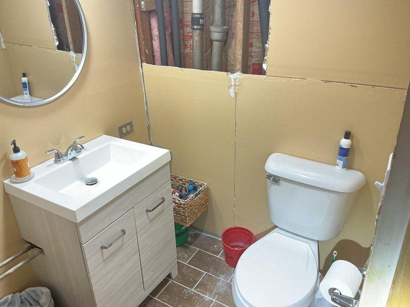 Responded to service call for bathroom plumbing assessment. Upon arrival, accessed concealed drain and waste lines by removing section of bathroom wall behind vanity area. Exposed vertical plumbing stack and associated drainage piping within wall cavity to evaluate system condition and identify source of drainage concerns. Documented existing plumbing configuration including PVC waste lines and supply connections for estimate preparation and future repair planning.