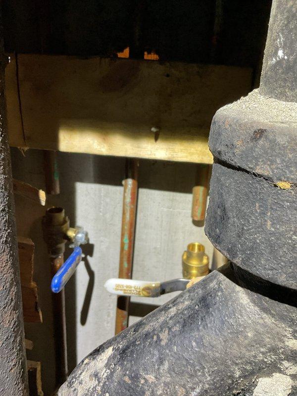 Completed commercial drain and sewer estimate inspection of plumbing infrastructure at a commercial facility. Documentation included exterior HVAC/plumbing connections with deteriorated pipe insulation on refrigerant lines and brass service valves, as well as an interior wall-mounted plumbing fixture access point with exposed rough-in plumbing requiring repair or replacement. Identified aging infrastructure components and provided comprehensive photographic documentation for estimate preparation.
