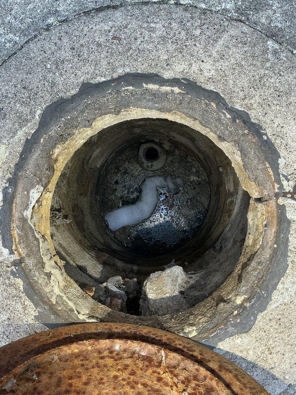 Responded to report of basement water leak with suspected collapsed line. Conducted thorough inspection of affected basement area, which revealed significant standing water accumulation on concrete floor and visible moisture damage throughout the space. Investigated exterior access point showing deteriorated concrete with exposed PVC piping components within drain opening. Documented extensive water infiltration affecting storage area with multiple wet zones identified. Photographed both interior basement flooding conditions and exterior drain access point to assess potential line collapse and determine scope of necessary repairs for quotation purposes.