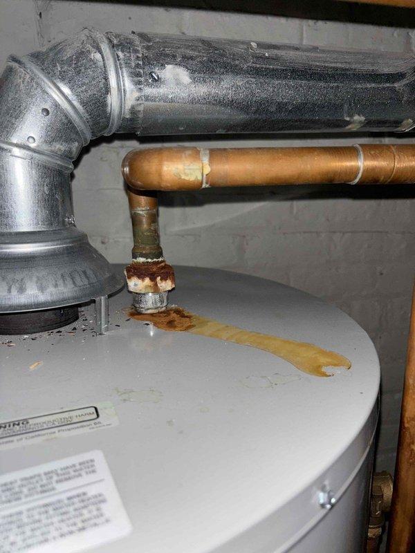 Responded to service call for multiple plumbing issues including a bathroom sink draining slowly due to clog that had worsened over the past week. Inspected and addressed the clogged bathroom sink drainage issue. Additionally, evaluated a leaking shut-off valve behind toilet that required replacement, as evidenced by corroded brass fitting with visible water damage and mineral deposits on adjacent water heater tank. Documented existing plumbing conditions including deteriorated valve connections and potential need for master bathroom shower drain rodding service.