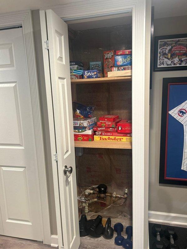 Conducted on-site assessment for sump pump and battery backup system installation in residential basement utility area. Evaluated existing sump pump configuration with white PVC discharge piping and circular sump basin currently installed in floor. Inspected overhead drainage routing and examined available space for potential battery backup integration. Documented current system layout including electrical connections, shelving placement, and accessibility constraints within the utility closet area. Provided comprehensive quote for new sump pump installation with battery backup system to ensure continued operation during power outages.