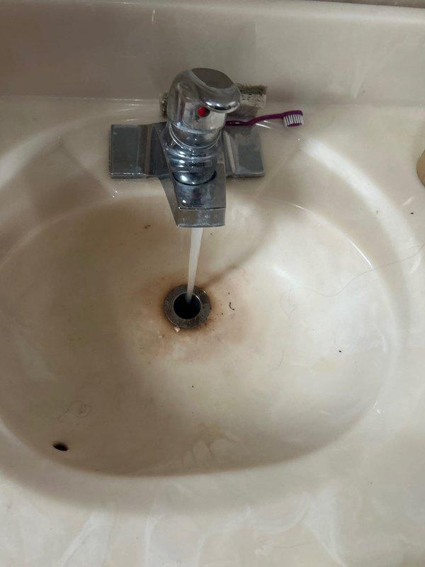Completed plumbing repair service involving severely corroded pipe fixture and bathroom sink faucet assembly. Addressed extensive rust deterioration on metal piping system and replaced worn chrome-plated faucet with visible mineral buildup and compromised finish. Customer approved financing for necessary repairs to restore proper function and prevent further water damage.
