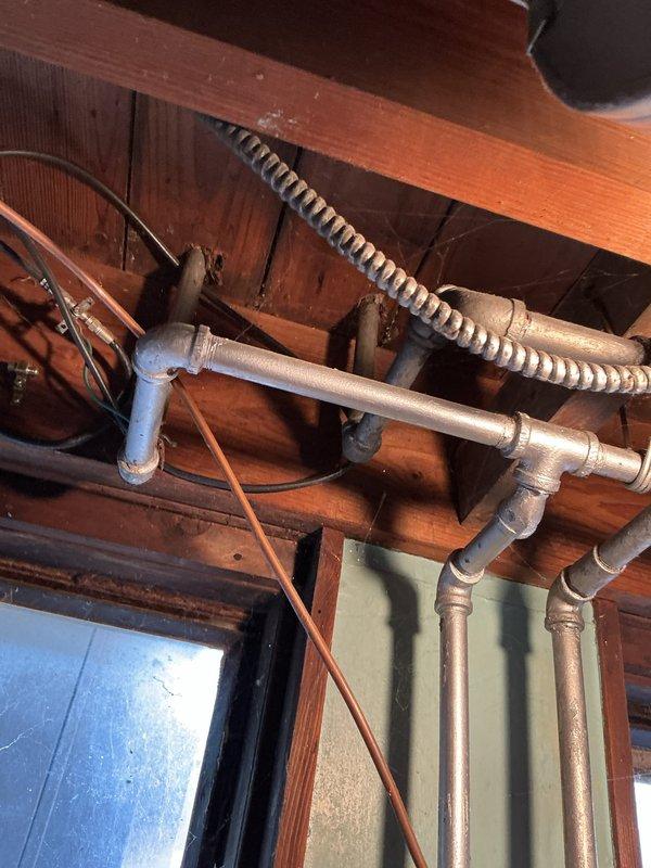Responded to ongoing faucet issues in a residence over 50 years old, addressing multiple leaking and non-functional fixtures. Inspected extensive plumbing system including utility room piping network and under-counter copper supply lines. Documented existing conditions of aging infrastructure, noting corroded copper pipes with oxidation and deteriorated connections throughout the water supply system requiring repair or replacement to restore proper function.