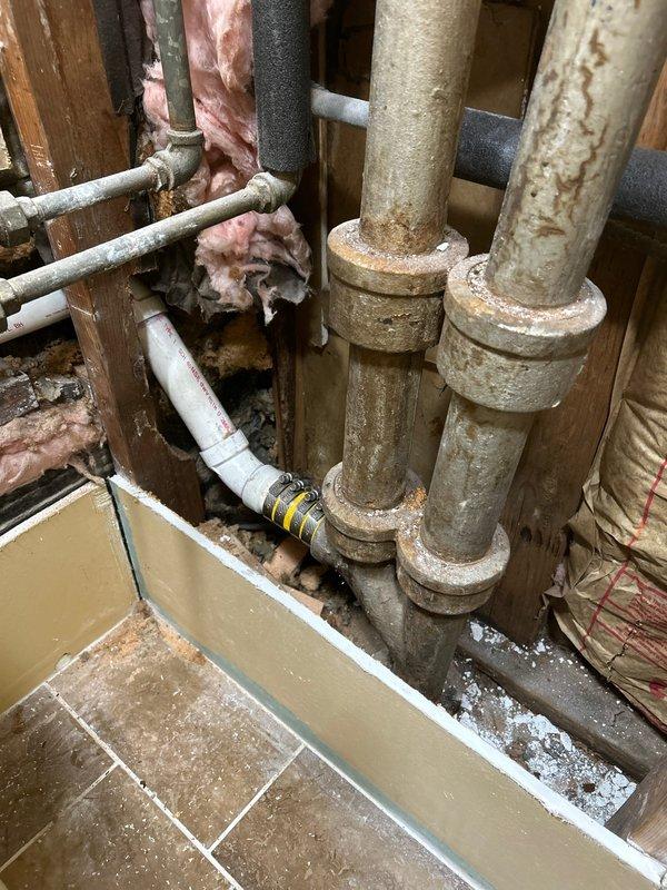 Completed plumbing installation work involving exposed piping systems within interior wall cavity. Installed and configured multiple water supply lines including horizontal metal pipes and vertical PVC drainage pipes, with proper insulation placement between wall framing members. Work included integration of new piping with existing plumbing infrastructure, ensuring proper connections and joint sealing at all coupling points.