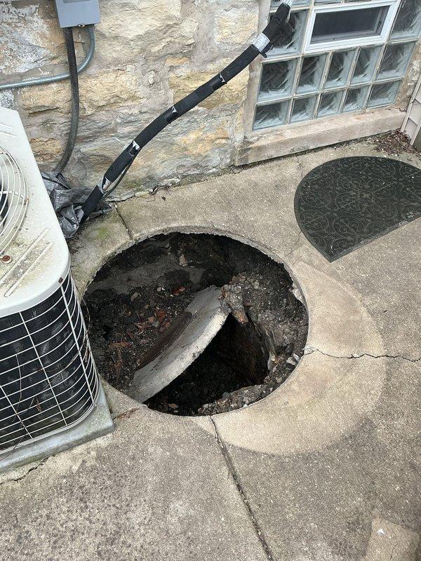 Conducted comprehensive site assessment for plumbing estimate involving collapsed catch basin and deteriorating interior piping systems. Exterior inspection revealed compromised catch basin with exposed cavity, debris accumulation, and structural failure in concrete pad adjacent to HVAC equipment. Interior evaluation documented aging galvanized steel supply lines exhibiting advanced corrosion, surface deterioration, and compromised integrity serving kitchen and laundry areas. Assessed existing brass valve assemblies with flexible connector tubing and identified corroded copper piping with visible patina requiring replacement to prevent future failures and ensure code compliance.