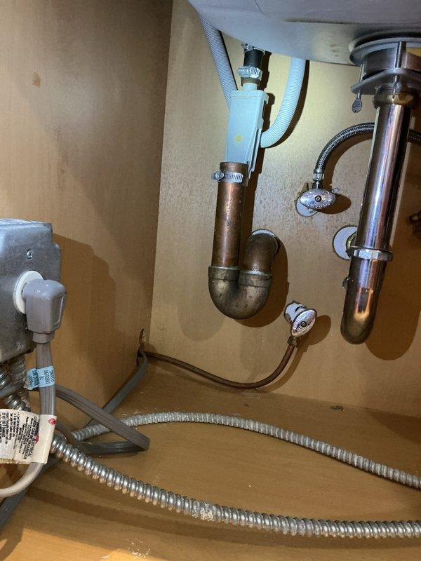 Removed existing garbage disposal unit and disconnected all associated electrical and plumbing connections. Installed new standard P-trap drain assembly with chrome-plated tailpiece to convert sink to conventional drainage configuration. Replaced kitchen faucet with new fixture, connecting hot and cold water supply lines using braided stainless steel flex hoses. Verified all connections for proper seal, tested drain flow and faucet operation, and confirmed no leaks present in supply lines or drain assembly upon completion.