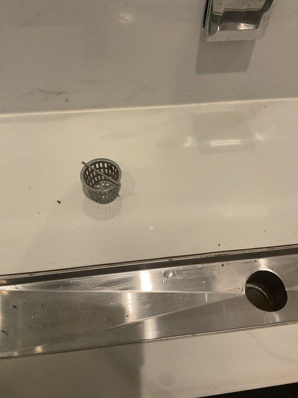 Responded to a completely clogged shower drain with no drainage. Removed and cleaned the linear drain grate and chrome drain strainer, extracting accumulated hair, soap residue, and debris causing the blockage. Tested water flow after clearing obstruction to confirm proper drainage was restored and all fixtures were functioning correctly.