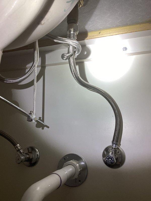 Completed installation of new handheld showerhead assembly with chrome finish. Verified all plumbing connections including flexible braided stainless steel supply lines, angle stop valve, and toilet tank connections were secure and functioning properly with no leaks detected.
