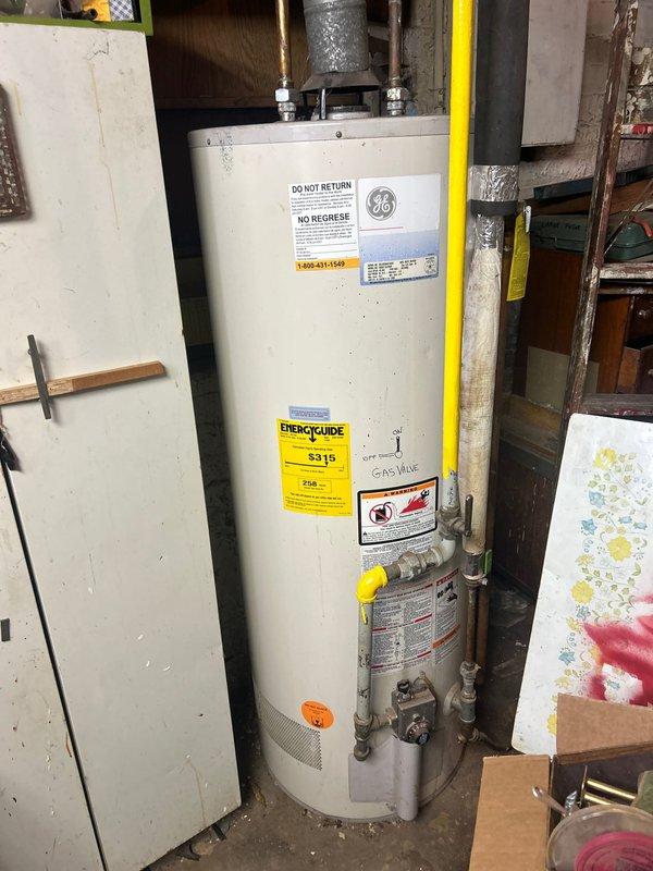 Conducted commercial water heater assessment for upgrading existing 50-gallon unit to 75-gallon capacity. Inspected current gas-fired water heater installation in basement mechanical room, documenting existing plumbing connections, gas line configuration, and venting system. Evaluated overhead piping infrastructure and available space for larger capacity unit replacement.