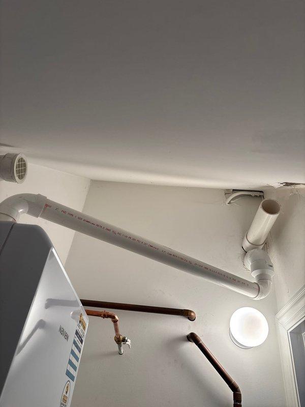 Responded to callback for recurring error code on plumbing system. Inspected utility room mechanical space including white PVC drainage/ventilation piping, copper supply lines with shut-off valves, and wall-mounted venting components. Documented existing pipe configuration and connections at wall and ceiling junctions. Issue requires further diagnosis to resolve persistent error code condition.