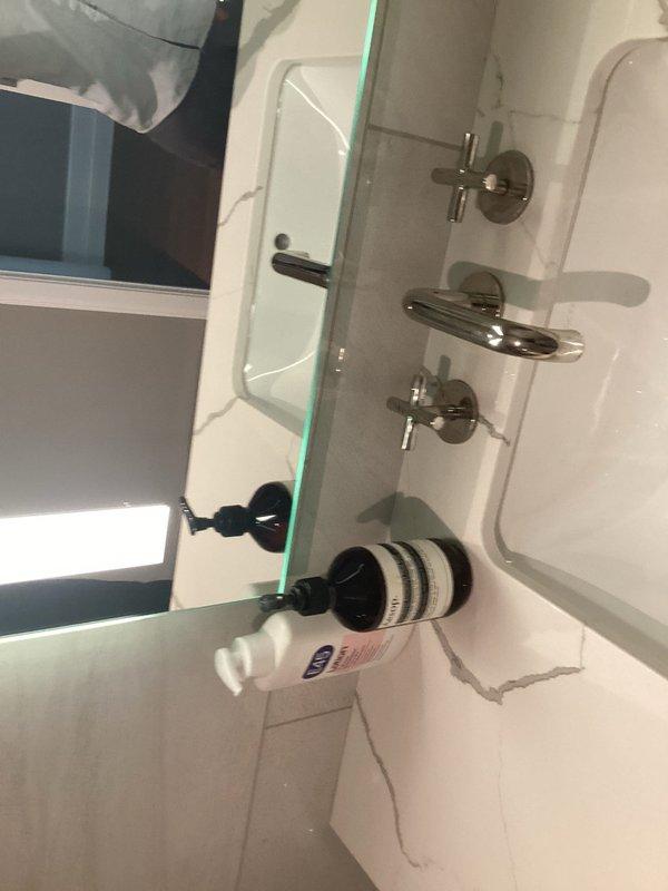 Responded to service call for multiple plumbing issues in residential condo unit. Addressed slow-filling toilet that was taking approximately two minutes to complete fill cycle and producing excessive noise after flushing. Inspected guest bathroom faucet experiencing persistent dripping at approximately 15-second intervals. Documented conditions of bathroom fixtures including standard two-piece toilet installation and wall-mounted three-piece faucet assembly with cross-handle valves. Washing machine servicing also requested as part of comprehensive plumbing maintenance visit.