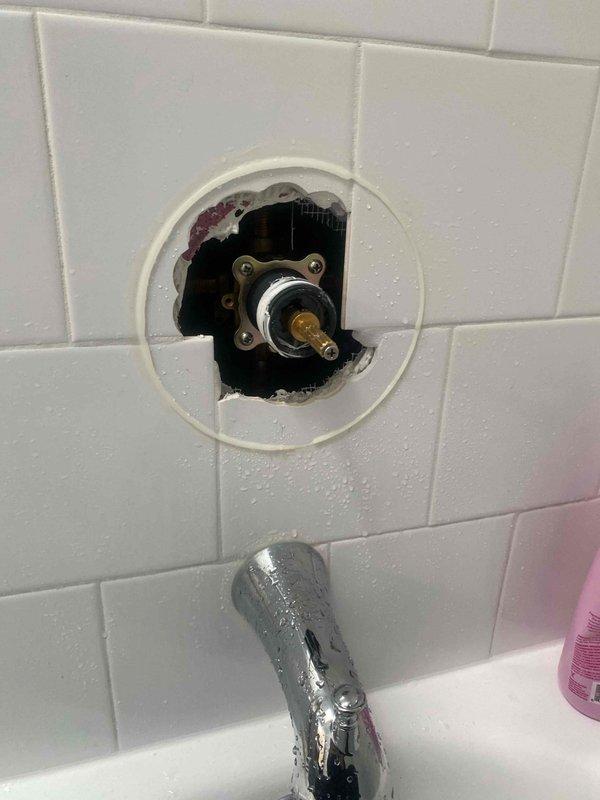 Responded to low water pressure complaint in second-floor bathroom of 20-year-old residence. Upon inspection, identified deteriorated shower valve cartridge causing restricted flow. Removed decorative trim plate and escutcheon to access valve assembly, revealing corrosion and mineral buildup on valve stem and internal components. Replaced faulty cartridge, cleaned mounting area, and reinstalled handle assembly. Tested water pressure and temperature control to confirm proper operation and full flow restoration.