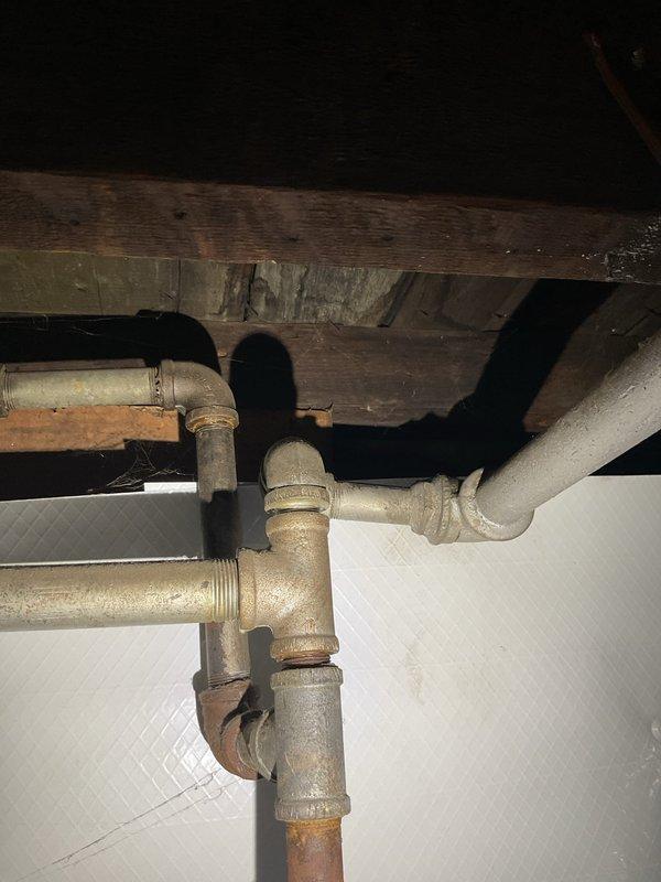 Responded to service call for gas pipe leak that had been temporarily repaired by utility company and required permanent replacement. Inspected aging galvanized gas piping system in basement area, identified compromised section with leak at threaded joint connection, and replaced damaged pipe segment with new black iron pipe using proper threading and joint compound to ensure gas-tight seal. Performed pressure test on repaired gas line to verify system integrity and absence of leaks. Additionally addressed dripping single-handle shower faucet in bathroom by replacing worn cartridge assembly and testing for proper operation and complete shutoff.