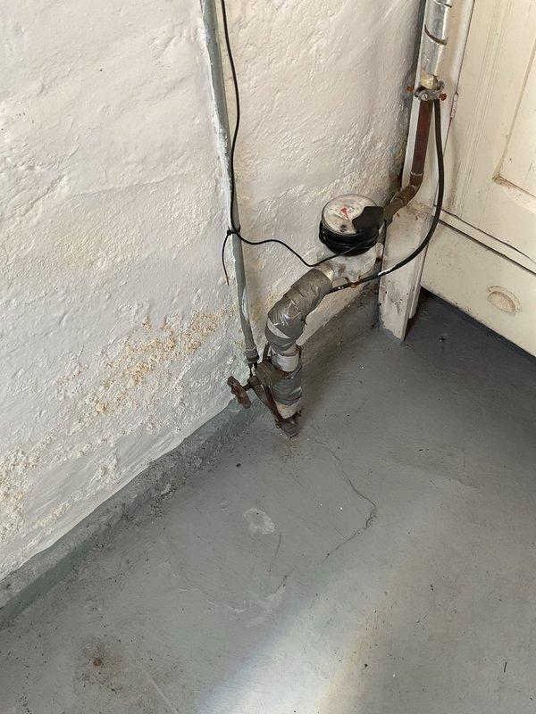 Responded to service call for sewer scope estimate at residential property. Upon arrival, inspected basement utility area to assess plumbing system and identify access points for camera inspection. Observed aging plumbing infrastructure including galvanized piping with visible corrosion, utility sink with deteriorated base framing, and floor drain connections with PVC drainage pipes. Documented existing conditions including water staining on concrete floor indicating potential drainage issues, compromised sink support structure, and corroded water meter assembly. Photographed plumbing configuration and areas of concern to provide comprehensive estimate for sewer scope inspection and recommended repairs based on visual assessment of accessible plumbing components.