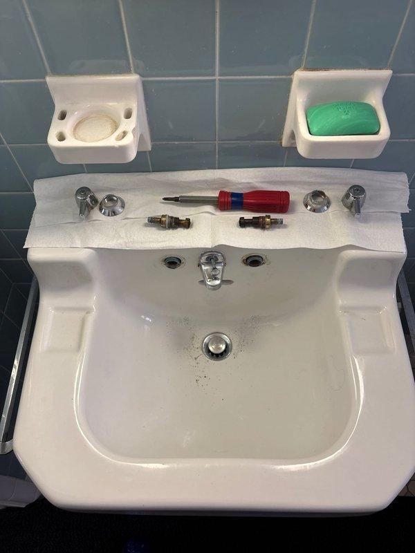 Completed comprehensive plumbing service including gas valve and vent installation for dryer, shower faucet stem replacement, and toilet flow valve replacements on two fixtures. Diagnosed sink issue with discolored water in toilet tank, identifying contamination requiring attention. Replaced faucet stems and cartridges on wall-mounted bathroom sink, with chrome hardware and brass valve components installed. Documented water quality concerns in toilet tank showing significant yellowish-brown discoloration and mineral deposits along waterline and interior surfaces.