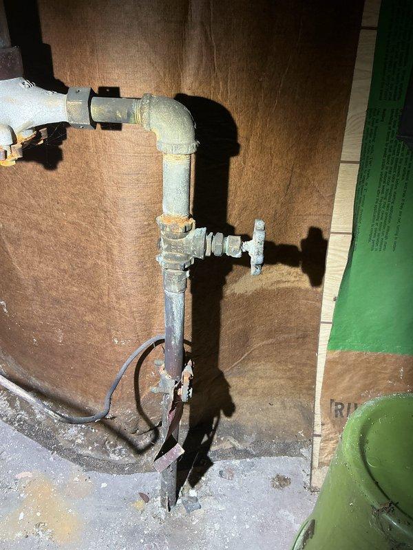 Completed water line replacement from buffalo box to water meter and replaced drain lines servicing kitchen and bathroom fixtures. Installed new galvanized piping assembly with proper fittings and connections, securing all components against backing material in utility area. All work performed to code specifications with proper valve installation and drainage configuration to ensure reliable water supply and waste removal for affected areas.