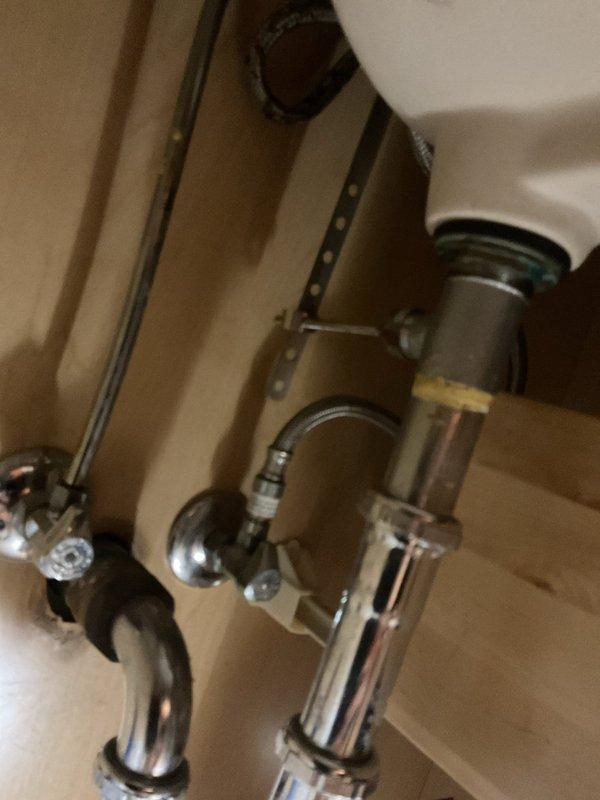 Responded to service call for malfunctioning bathroom sink stopper and drainage issue. Upon inspection, assessed the pop-up drain assembly beneath the undermount porcelain sink and verified the P-trap configuration and drain connections. Serviced the chrome pop-up stopper mechanism to restore proper operation, ensuring the sink now drains efficiently and the stopper functions as intended.