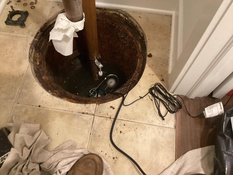 Removed existing ejector pump from corroded sump basin and installed new submersible ejector pump unit. Installed new 2-inch check valve with banding to prevent backflow, utilizing 2-inch copper piping from the new pump discharge. Resealed basin lid upon completion to ensure proper containment and system integrity.