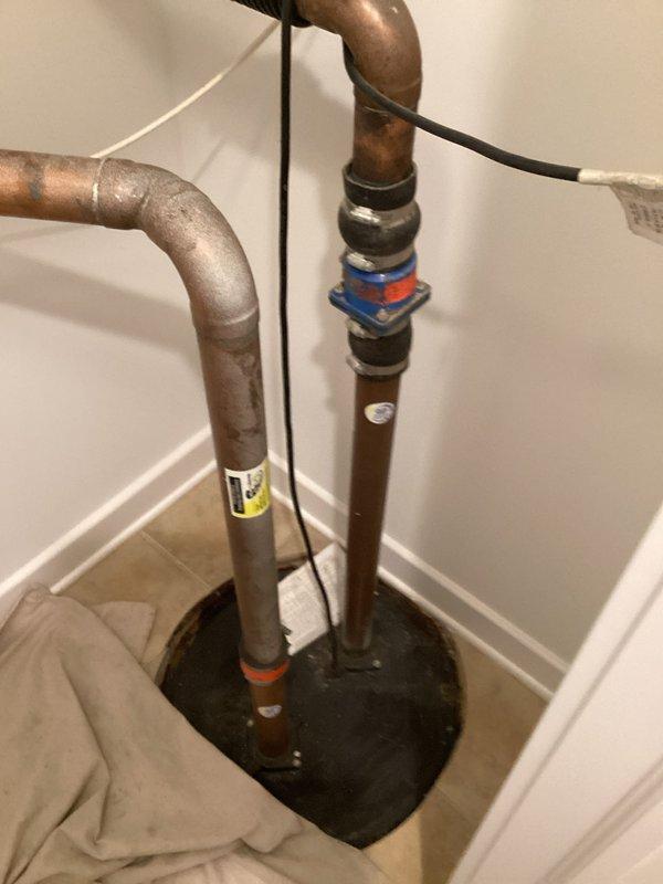 Removed existing ejector pump from corroded sump basin and installed new submersible ejector pump unit. Installed new 2-inch check valve with banding to prevent backflow, utilizing 2-inch copper piping from the new pump discharge. Resealed basin lid upon completion to ensure proper containment and system integrity.