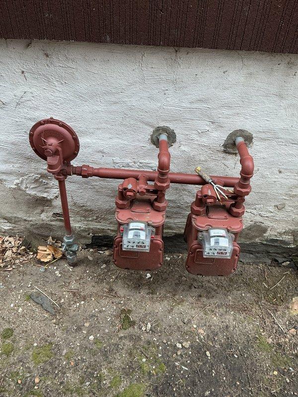 Replaced defective gas line shut-off valve to facilitate dryer installation at commercial property. The existing valve assembly servicing the dual gas meter installation showed signs of weathering and required replacement to ensure proper gas flow control and safe appliance connection. Work completed at exterior gas meter location mounted on building foundation.