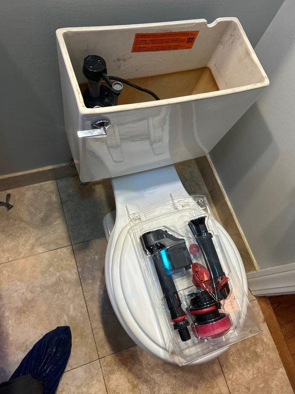 Completed installation of new toilet unit. Replaced existing fill valve assembly with new mechanism to ensure proper water flow and tank filling operation. Removed tank lid to access internal components and installed black fill valve system with adjustment features. Verified proper seating of all tank components and confirmed water level settings. Tested flush mechanism and fill cycle to ensure optimal performance and proper shutoff function.
