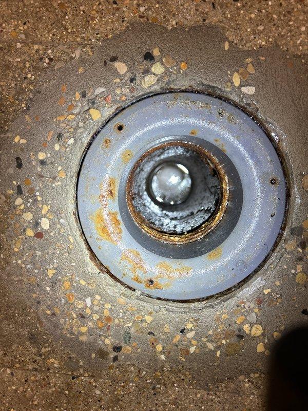 Responded to a plumbing service call for a corroded floor drain requiring replacement or repair. Upon inspection, identified significant rust deterioration on the drain fixture's metal components, with the middle ring showing extensive orange-brown corrosion that compromised the drain's integrity and functionality. Assessed the installation for proper sealing and drainage capability, documented the existing condition with photographs, and presented repair options to address the corroded drain assembly and restore proper operation.