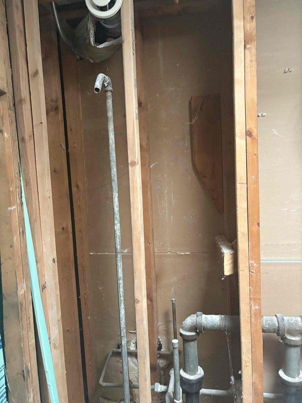 Conducted comprehensive assessment of existing plumbing infrastructure to provide estimate for complete galvanized pipe replacement throughout the property. Evaluated exposed galvanized water supply lines within wall cavities, documenting deterioration and corrosion levels requiring full system upgrade. Assessed requirements for water heater replacement and associated gas line relocation to accommodate new equipment placement and meet current code requirements. Documented existing plumbing configuration including drain assemblies, supply lines, and venting systems to develop accurate scope of work for complete repiping project.