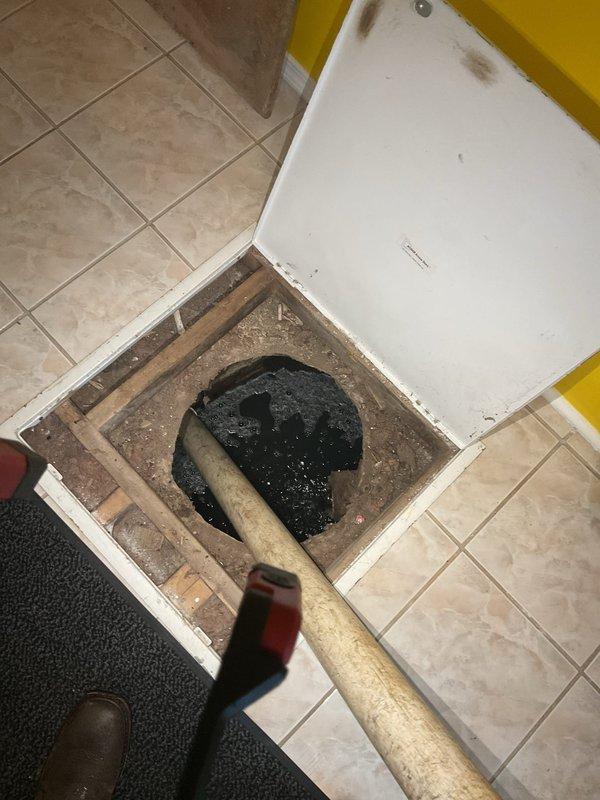 Responded to service call for pump catch basin maintenance. Upon arrival, accessed floor-mounted catch basin through tile floor access panel, revealing accumulated debris and standing water in the basin cavity. Removed organic debris including leaves, twigs, pine needles, and dirt that had collected on entrance mat and migrated into the drainage system. Cleared blockage from pump catch basin to restore proper drainage function and prevent potential flooding or water backup issues.
