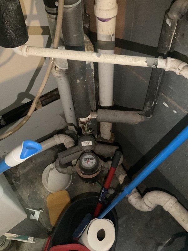 Conducted plumbing assessment of basement ejector pump system and evaluated discharge piping options for connection to sanitary sewer line. Documented existing PVC drainage infrastructure, water meter assembly, utility sink installation, and current pump configuration to provide customer with multiple solutions for proper ejector pump discharge routing.
