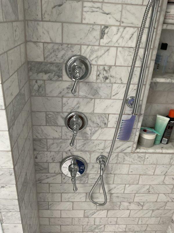 Responded to morning appointment for shower valves that would not turn on or off properly. Upon inspection, found faulty shower control valves in the tiled shower stall requiring replacement. Removed three defective chrome shower control valves and installed new chrome valve assemblies with circular faceplates and lever handles. Tested all three valves for proper operation, ensuring smooth on/off functionality and temperature control. Verified water pressure and checked for leaks at all connections. All fixtures now operating correctly with full shut-off capability restored.