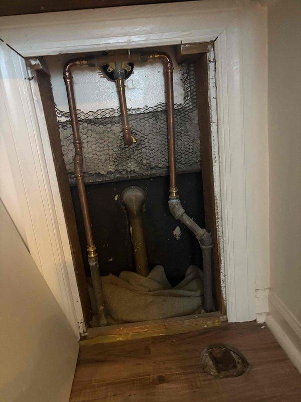 Conducted water heater assessment and replacement estimate for a 16-year-old 50-gallon tank unit located in confined access space beneath staircase. Evaluated existing plumbing infrastructure including copper supply lines, brass shutoff valves, and drainage configuration to determine feasibility of upgrading to hybrid heat pump water heater. Provided professional recommendation regarding optimal tank capacity between 50-gallon and 65-gallon options based on household demand, available installation space, and compatibility with existing HVAC systems and utility connections.