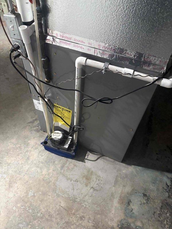 Conducted water heater assessment and replacement estimate for a 16-year-old 50-gallon tank unit located in confined access space beneath staircase. Evaluated existing plumbing infrastructure including copper supply lines, brass shutoff valves, and drainage configuration to determine feasibility of upgrading to hybrid heat pump water heater. Provided professional recommendation regarding optimal tank capacity between 50-gallon and 65-gallon options based on household demand, available installation space, and compatibility with existing HVAC systems and utility connections.
