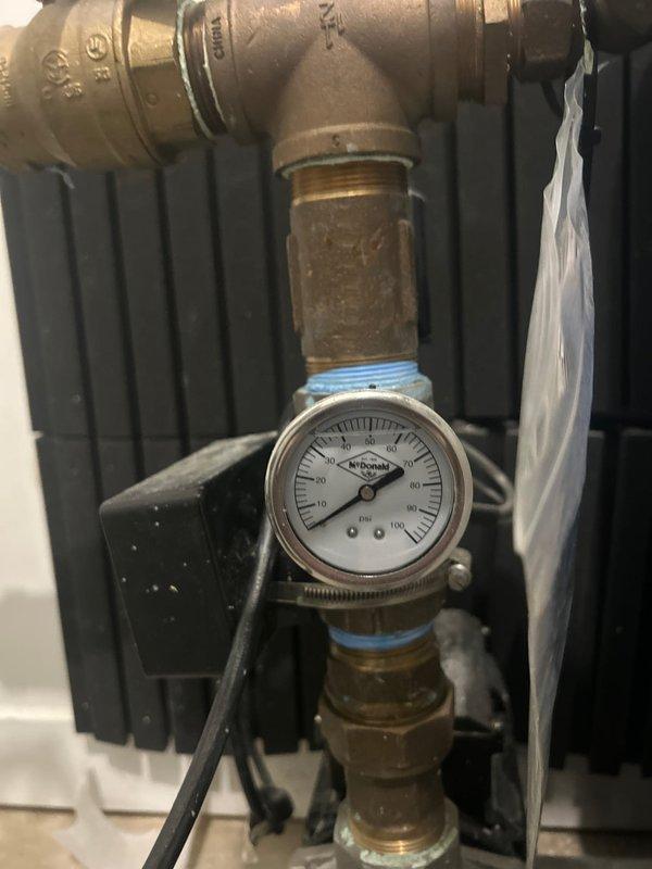 Returned to property to complete follow-up plumbing inspection and pressure testing. Installed new pressure gauge on water supply system with brass fittings and proper PTFE thread seal tape application to ensure leak-free connections. Verified system pressure readings using digital pressure measurement device, confirming proper operating pressure within acceptable range. Documented all work with photos showing gauge installation and pressure verification readings for service records.