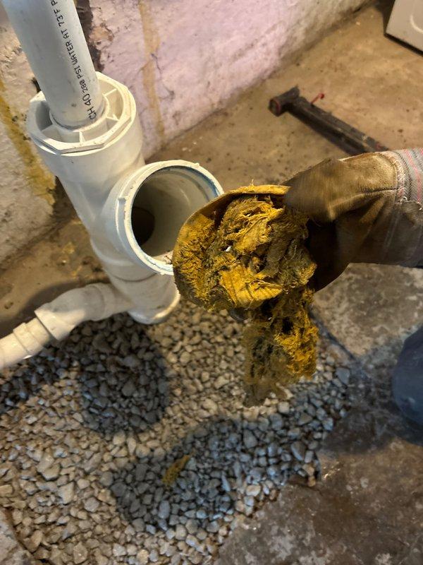 Responded to clogged drain service call and discovered severely corroded cast iron drain pipe in basement causing drainage issues. Removed and replaced deteriorated pipe section showing extensive rust buildup and interior blockage that had significantly reduced water flow capacity. Installed new PVC drain assembly with proper connections and tested system to ensure proper drainage and no leaks.