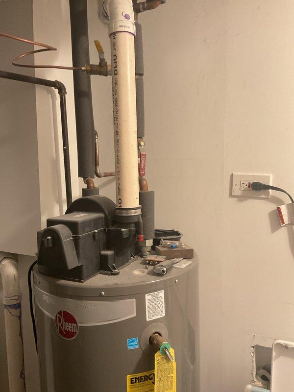 Responded to service call for no hot water and non-functioning sump pump causing water accumulation. Upon inspection, identified failed condensate pump mounted on top of Rheem water heater in utility room. Condensate pump was not draining properly, causing backup and preventing normal operation. Serviced and tested pump assembly, verified proper drainage through PVC discharge lines, and restored hot water functionality. Confirmed all plumbing connections secure, checked electrical connections at wall outlet, and ensured water heater returned to normal operation. System tested successfully with no further water accumulation observed.