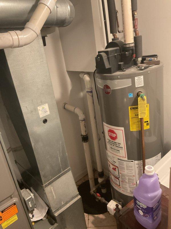 Responded to service call for no hot water and non-functioning sump pump causing water accumulation. Upon inspection, identified failed condensate pump mounted on top of Rheem water heater in utility room. Condensate pump was not draining properly, causing backup and preventing normal operation. Serviced and tested pump assembly, verified proper drainage through PVC discharge lines, and restored hot water functionality. Confirmed all plumbing connections secure, checked electrical connections at wall outlet, and ensured water heater returned to normal operation. System tested successfully with no further water accumulation observed.