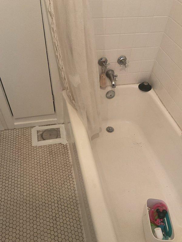 Responded to a bathroom flooding issue caused by bathtub drainage backing up through the floor overflow drain. Upon inspection, identified a clogged drain line affecting both the bathtub and kitchen sink plumbing system. Cleared the obstruction in the drainage system, tested water flow through the bathtub drain and verified proper drainage through the P-trap assembly and garbage disposal connection under the kitchen sink. Confirmed all fixtures were draining properly with no further overflow issues.