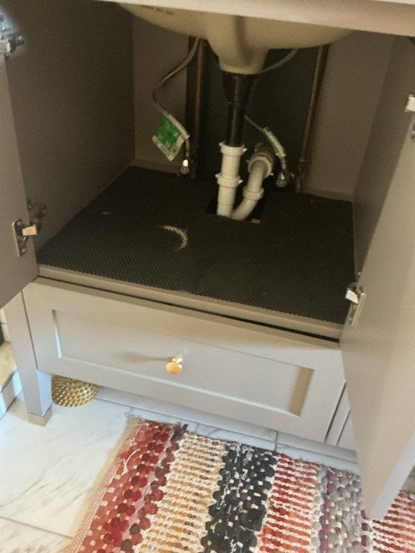 Responded to warranty callback for persistent bathroom sink leak after three previous service visits. Inspected under-sink plumbing including P-trap assembly and supply line connections. Identified source of ongoing leak and performed corrective repairs to resolve issue permanently. Documented installation with photos showing vanity cabinet interior, plumbing configuration, and all components for warranty records.