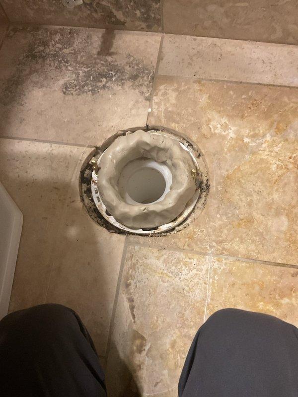 Completed toilet installation on third floor requiring two-person crew due to access and material handling requirements. Removed existing toilet fixture and assessed floor flange condition. Installed new two-piece white porcelain toilet with proper wax ring seal and mounting hardware, ensuring level placement and secure anchoring to floor flange. Reconnected water supply line and tested for proper fill, flush operation, and verified no leaks at base or supply connection. Floor drain visible in work area showed signs of previous moisture exposure with staining on surrounding tile, though not related to current installation scope. New toilet positioned against tiled wall with adequate clearance for operation and maintenance access. All components functioning properly upon completion with no water leakage detected during final inspection.