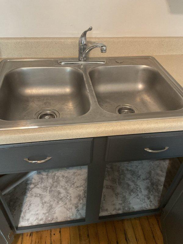 Installed customer-supplied chrome single-handle kitchen faucet on double-basin stainless steel sink. Replaced faulty gasket and addressed low water pressure issue on hot water supply line. Verified proper drainage connections, tested water flow and pressure on both hot and cold lines, and ensured all supply connections were secure with no leaks detected upon completion.