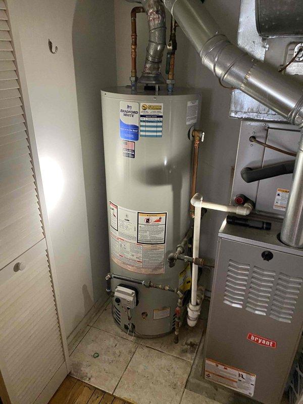Responded to service call for non-functioning 40-gallon Bradford White tank-style water heater approximately 6 years old. Upon inspection, documented existing water heater installation in utility room with connected copper supply lines, brass fittings, and gas control valve assembly. Assessed unit condition and photographed equipment specifications, manufacturer labels, and existing plumbing connections. Prepared estimate for water heater replacement, pending customer authorization for parts and labor to proceed with installation.