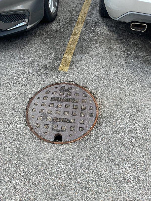 Responded to service call for sewer drain backup in parking lot area. Conducted on-site inspection of catch basin and drainage system, documented existing conditions of manhole cover and surrounding pavement surface showing signs of weathering and potential drainage issues. Performed visual assessment to determine scope of work needed for proper remediation of the backup condition.