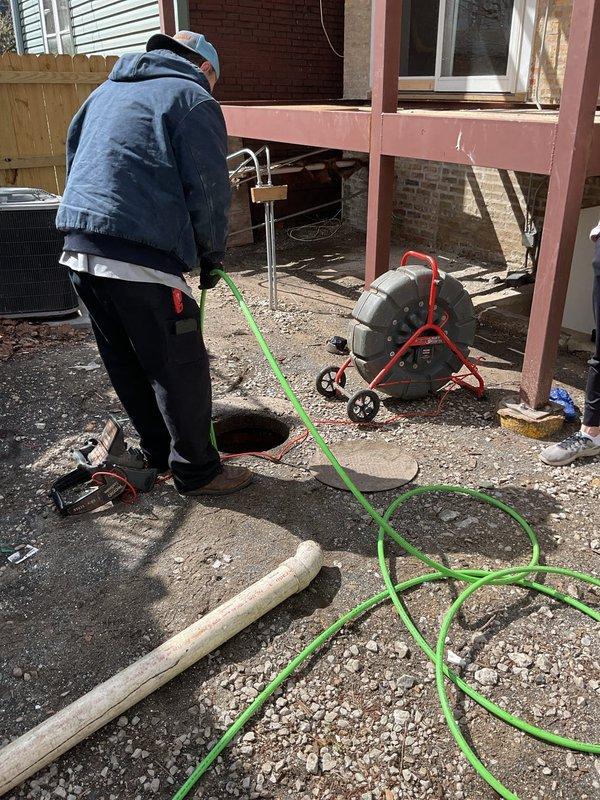 Responded to clogged drain service call at residential property. Upon arrival, accessed exterior sewer cleanout in backyard area. Deployed power drain cleaning machine with cable to clear main sewer line blockage. Successfully removed obstruction and restored proper drainage flow. Verified clearance by running water test through interior plumbing fixtures. Replaced cleanout cap and secured work area upon completion.